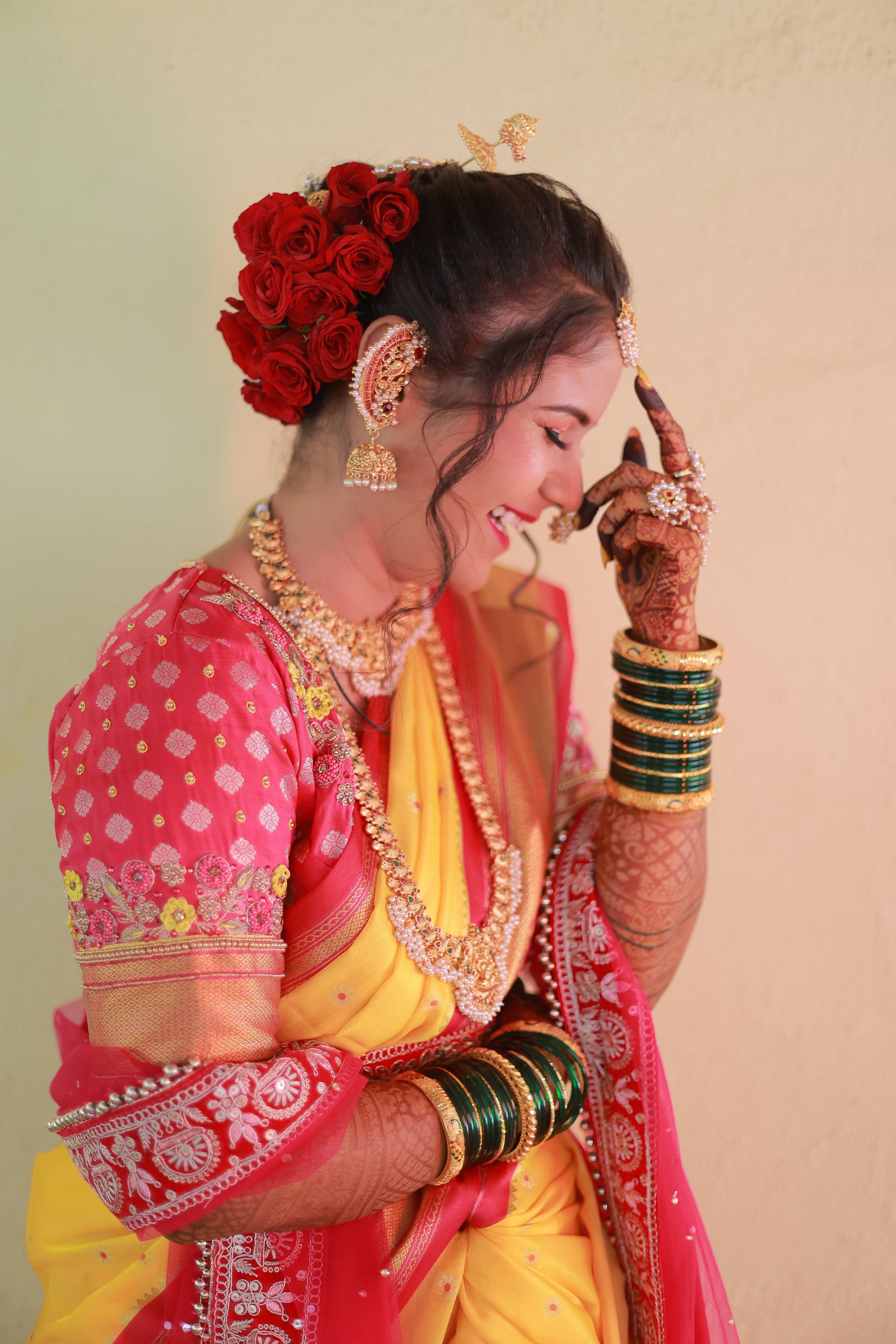Candid bride in yellow and pink wedding attire with rose gajra