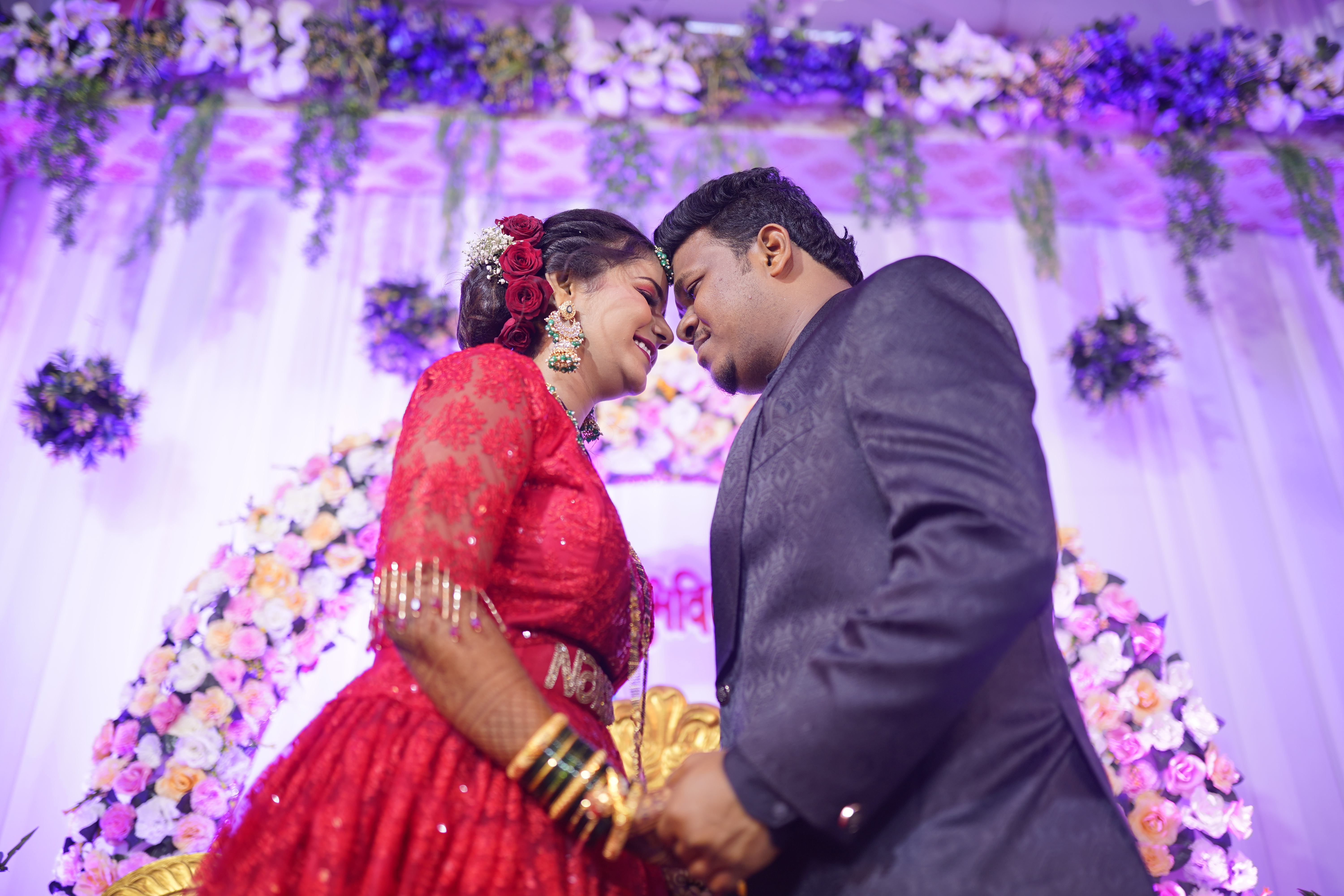 Candid couple intimate moment purple floral backdrop